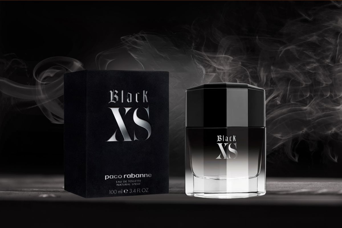 Paco Rabanne Black XS perfume bottle and box displayed with smoky accents on a dark background.
