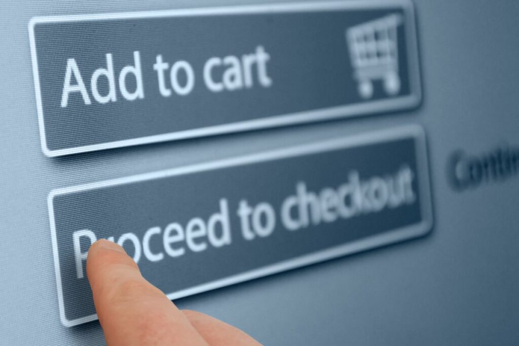 A close-up of a finger clicking the 'Proceed to checkout' button on an online shopping website.