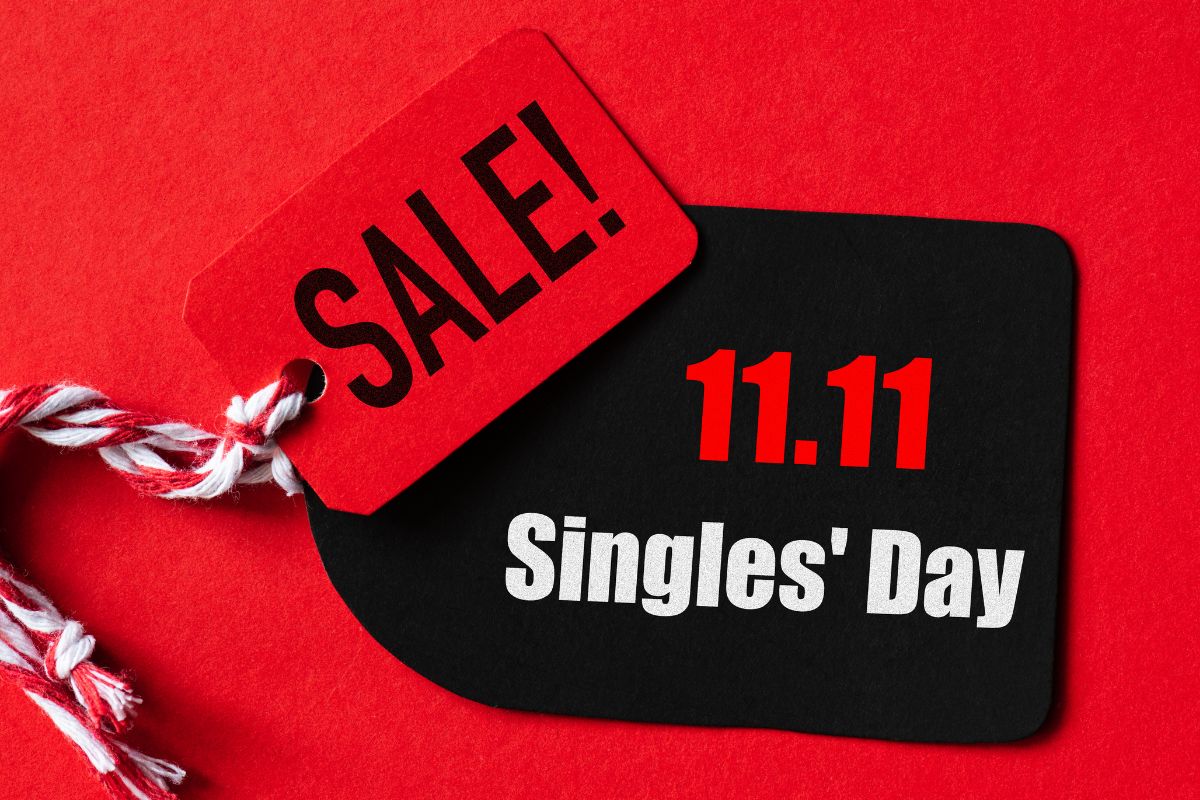 Red and black tags on a red background, displaying 'SALE!' and '11.11 Singles' Day' with a red and white string attached.