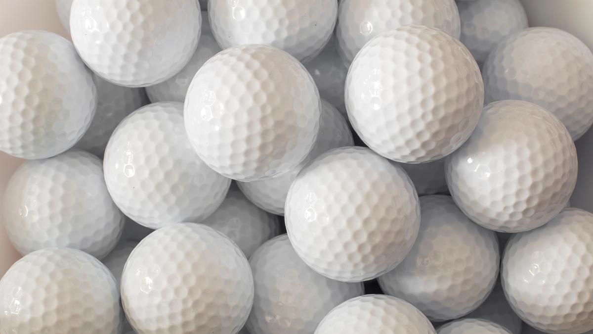 A tightly packed collection of pristine white golf balls, showcasing their dimpled texture and uniform design.