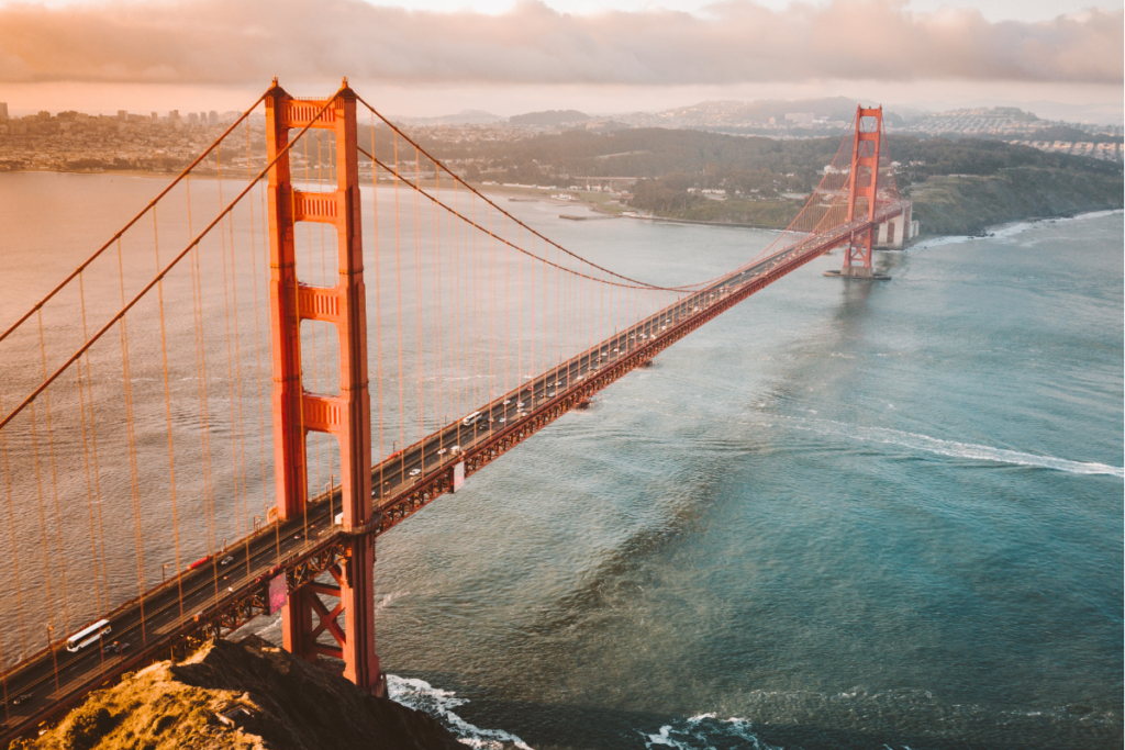 Aerial view of the Golden Gate Bridge spanning across the San Francisco Bay with the cityscape in the background.