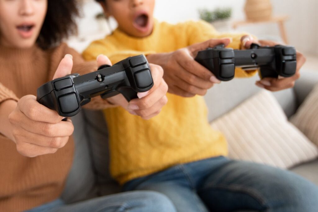 Two excited players holding controllers, reacting intensely while playing a game together.