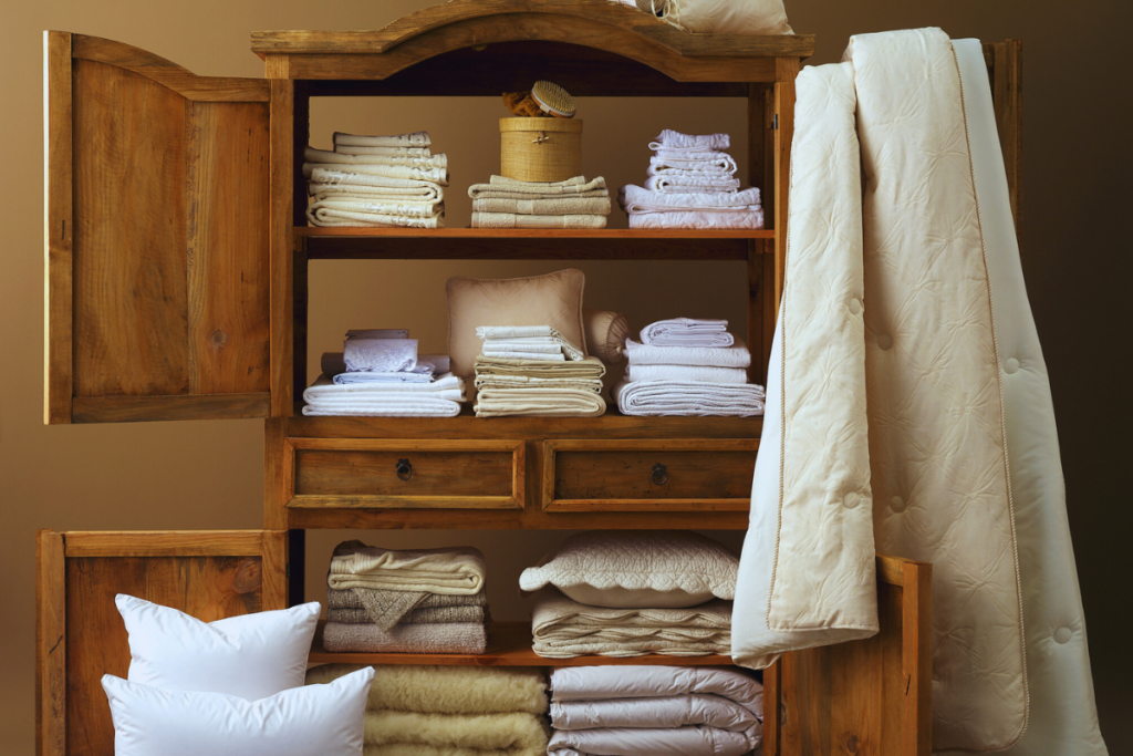 Minimalist stack of white folded linens placed on a clean, light surface with a plain background.