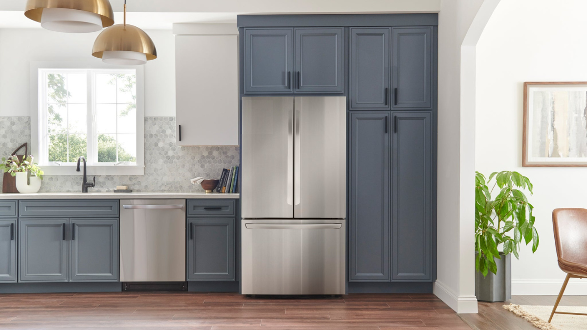 Modern kitchen design featuring navy blue cabinets, stainless steel French door refrigerator, stylish pendant lights, and minimalist decor.