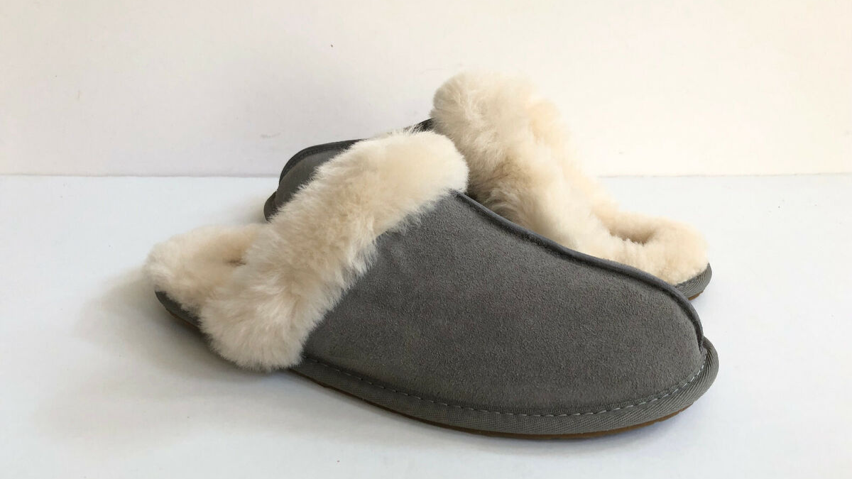 Cozy gray suede slippers with plush white fur lining, offering warmth and comfort for indoor wear.