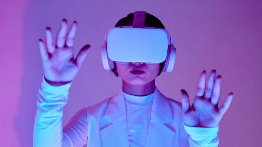 A woman wearing a VR headset, immersed in a virtual experience, with a neon-lit background.