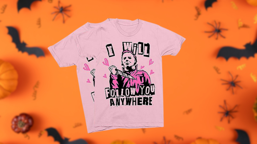 Pink T-shirt with a graphic of Michael Myers holding a knife, surrounded by pink hearts, and the text 'I WILL FOLLOW YOU ANYWHERE,' set against a Halloween-themed background.