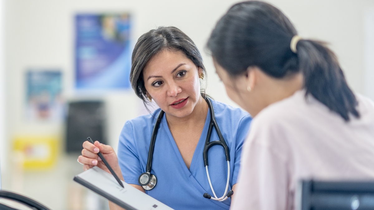 Alt text: Woman discussing preventive health screenings for women with healthcare provider during annual checkup